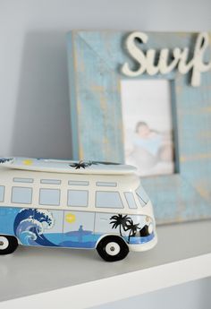 a surf bus figurine sitting on top of a shelf next to a frame