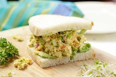 there is a sandwich that has been cut in half on a cutting board next to broccoli