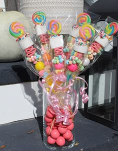 a vase filled with candies and lollipops on top of a table