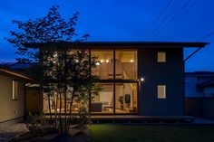 a modern house lit up at night with the lights on