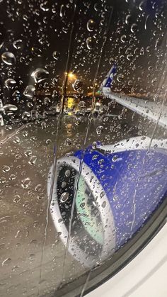 an airplane is seen through the rain covered window