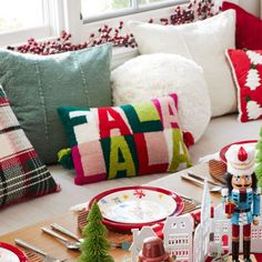 a christmas table setting with red and white plates, napkins, silverware and other holiday decorations