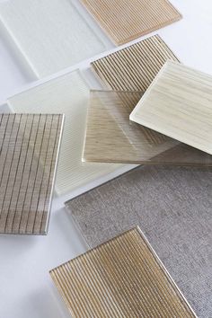 several different types of wood flooring samples on the ground, including one with white and beige stripes