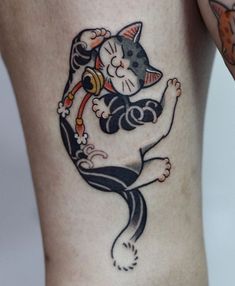 a woman's leg with a cat tattoo on it