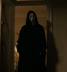 a person in a dark room with a mask on