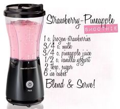 a blender filled with pink liquid on top of a white table next to a sign that says strawberry - pineapple smoothie