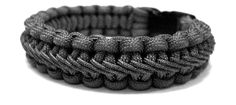 a black and white photo of an unzipped bracelet with braiding on it