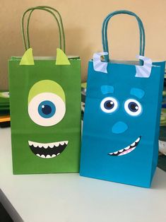 two paper bags with monsters on them sitting on a table