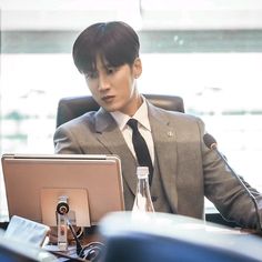 a man sitting at a desk with a laptop computer in front of him on his lap