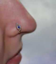 a woman's nose with a small blue stone in the middle of her nose