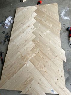 some wood is laying on the floor and being made into a christmas tree ornament