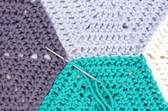 two crocheted pieces of fabric with needles