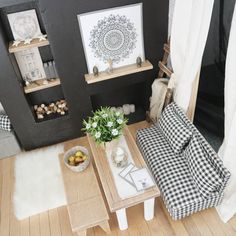 a living room filled with furniture next to a white curtain and wooden floored walls