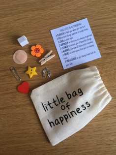 a little bag of happiness on a table with some pins and magnets next to it