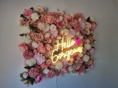 a flower wall with the word hello gorgeous written on it and flowers all over it