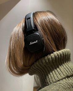 the back of a woman's head wearing black headphones