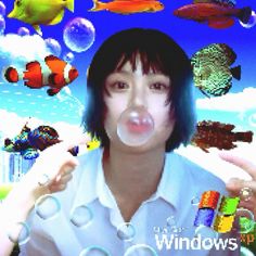 a woman blowing bubbles in front of an image of fish and sea creatures on the screen