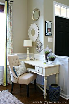 a desk with a chair, lamp and pictures on the wall