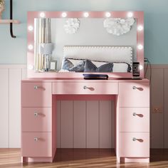 a pink vanity table with lights on it