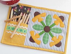 a close up of a patchwork place mat on a table with scissors and yarn