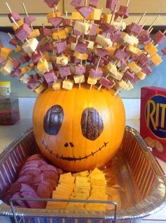 an orange pumpkin with marshmallows on it's head sitting in a basket