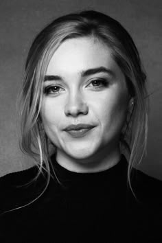 a black and white photo of a woman with blonde hair wearing a turtle neck sweater