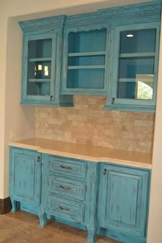 a kitchen with blue cabinets and marble counter tops