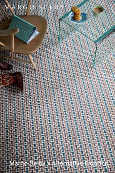 a chair and table in a room with a rug on the floor next to it