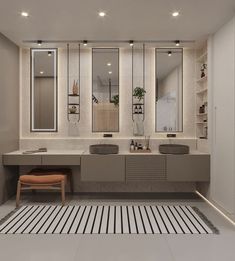 a bathroom with two sinks, mirrors and a bench in the middle of the room