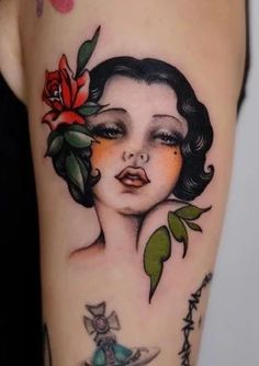 a woman's face with flowers and leaves on her arm