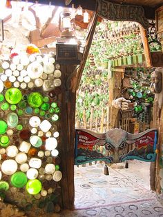 an open door to a store with lots of glass bottles on the walls and doors