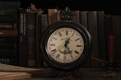 an alarm clock sitting on top of a table next to books