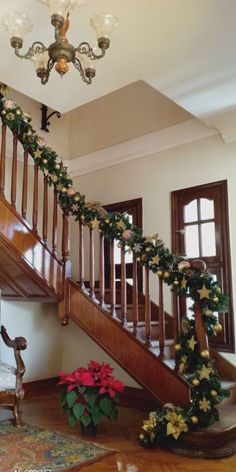 a staircase decorated for christmas with garland and poinsettis on the banister