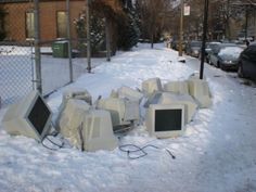 there are many old computers that have been left out on the sidewalk in the snow