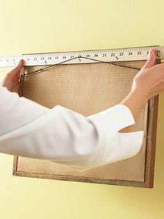 a person holding a ruler in front of a box