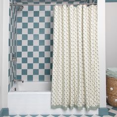 a bathroom with blue and white tiles on the walls, shower curtain, tub and rug