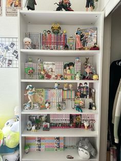 a book shelf filled with lots of books and figurines on top of it