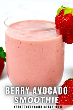 a glass filled with strawberry smoothie next to two strawberries