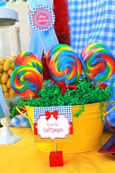 colorful lollipops in a yellow bucket on a table at a birthday party