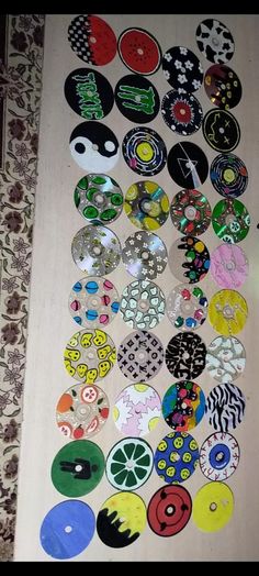 a bunch of different colored and black and white buttons on a table with wallpaper