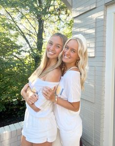 two young women are hugging each other outside