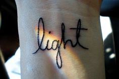 a wrist tattoo with the word light written on it