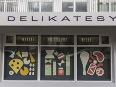 the front window of a delikatesy store with colorful artwork on it's windows