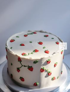 a white cake with red berries on it