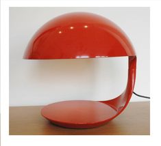 a red lamp sitting on top of a wooden table