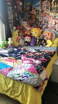 a bed covered in lots of stuffed animals next to a wall with pictures on it