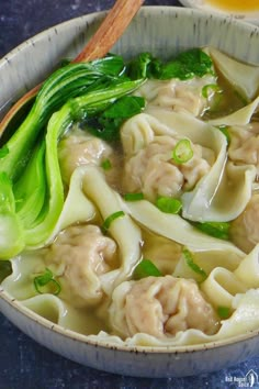 a bowl of wonton soup with broccoli and noodles