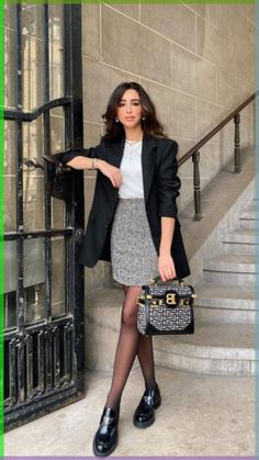 a woman in black and white holding a purse