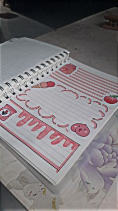 an open spiral notebook sitting on top of a table