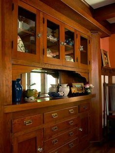 a wooden china cabinet with glass doors and drawers